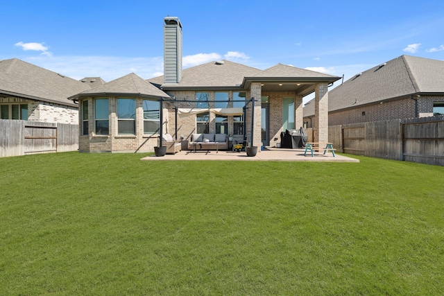 back of property featuring a lawn, brick siding, a fenced backyard, and a patio area