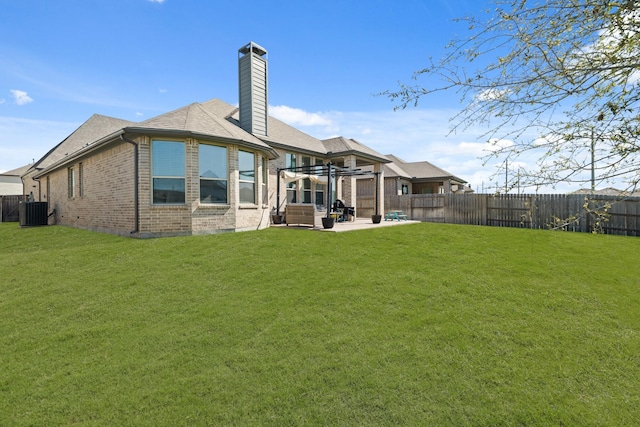 back of house featuring a patio, brick siding, a fenced backyard, and a lawn