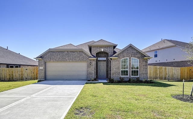 669 Woodhaven Lakes Dr, La Marque, TX 77568 - french provincial home featuring fence, a garage, concrete driveway, brick siding, and a front lawn