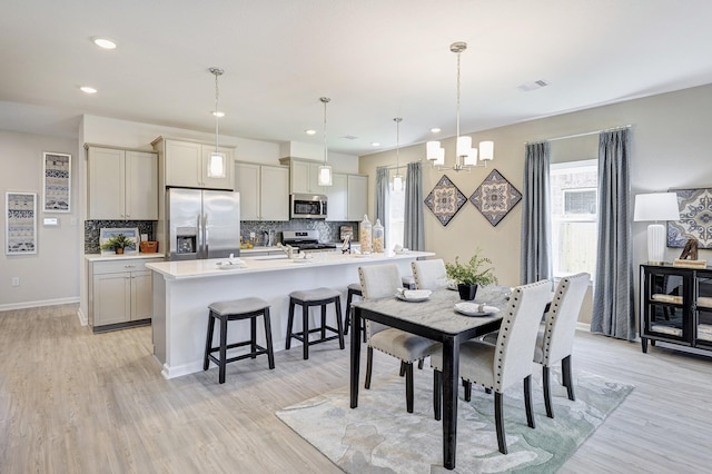 672 Woodhaven Lakes Dr, La Marque, TX 77568 - dining area featuring light wood-type flooring, plenty of natural light, and visible vents