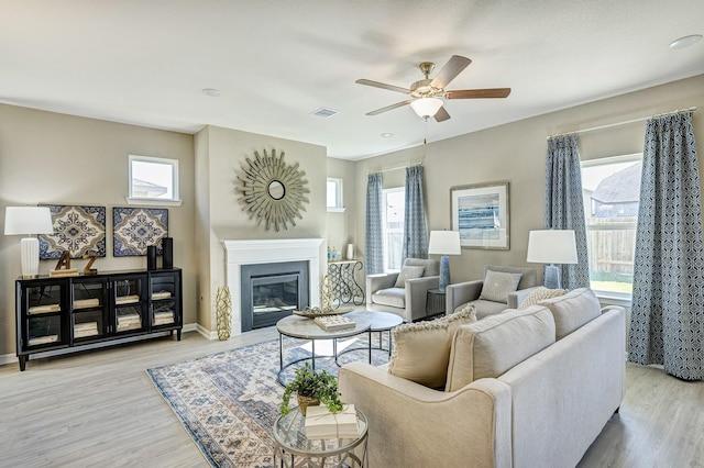 672 Woodhaven Lakes Dr, La Marque, TX 77568 - living room featuring light wood-type flooring, a ceiling fan, plenty of natural light, and visible vents