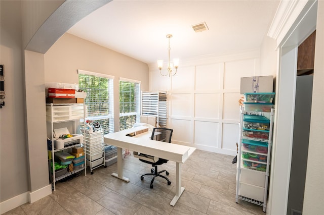 office with visible vents, a decorative wall, and an inviting chandelier