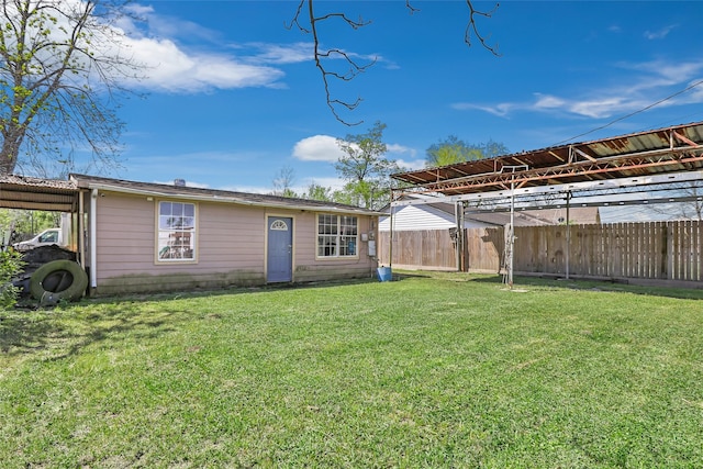 13022 Gladden Dr, Houston, TX 77049 - back of house featuring a lawn, a carport, and fence