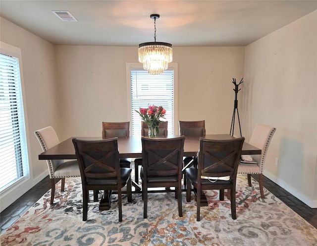 dining area featuring visible vents, baseboards, an inviting chandelier, and a healthy amount of sunlight