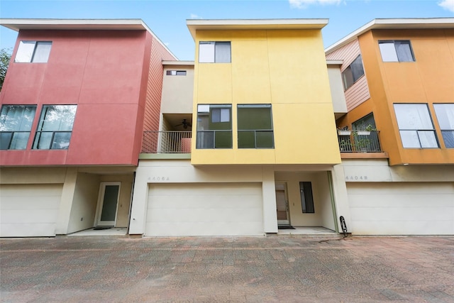 4406 Spencer St Unit A, Houston, TX 77007 - view of front of home with stucco siding, an attached garage, and a balcony