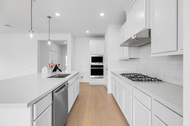 28810 Copper Ridge Dr, Fulshear, TX 77441 - kitchen featuring stainless steel appliances, under cabinet range hood, light countertops, decorative backsplash, and recessed lighting