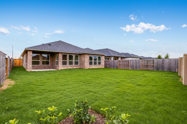 28810 Copper Ridge Dr, Fulshear, TX 77441 - rear view of property featuring brick siding, a fenced backyard, a patio area, and a shingled roof
