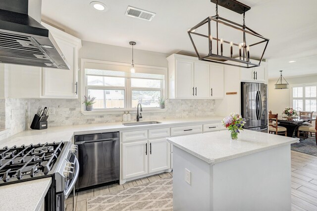 2227 Hialeah Dr, Houston, TX 77018 - kitchen featuring stainless steel appliances, decorative backsplash, a sink, visible vents, and wall chimney exhaust hood