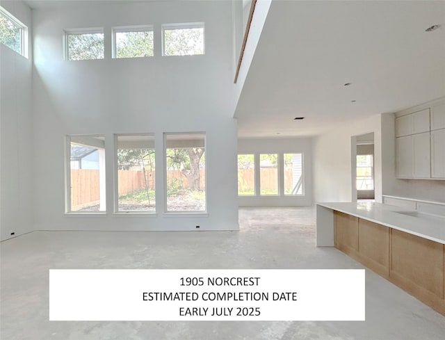 1905 Norcrest Dr, Houston, TX 77055 - unfurnished living room featuring concrete flooring, plenty of natural light, and a high ceiling