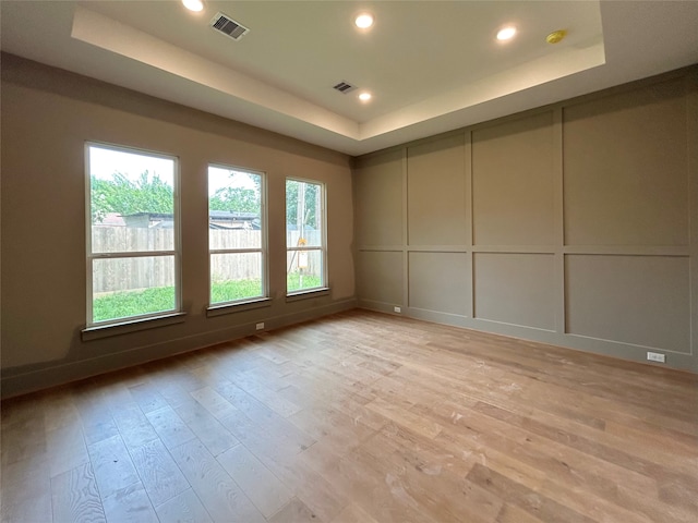 1905 Norcrest Dr, Houston, TX 77055 - empty room featuring a raised ceiling, a decorative wall, light wood-style flooring, a smoke detector, and recessed lighting