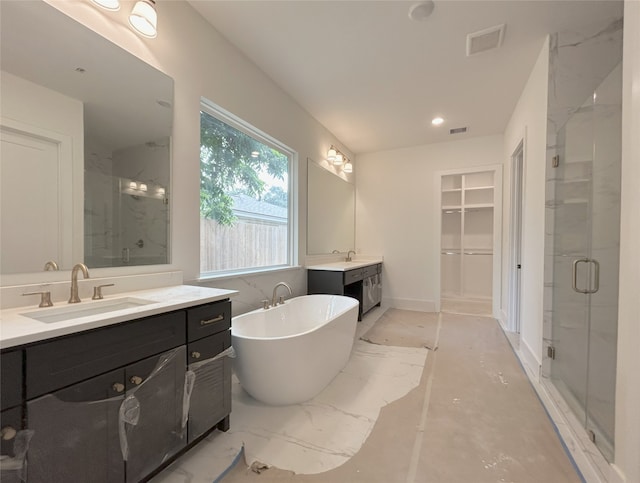 1905 Norcrest Dr, Houston, TX 77055 - bathroom featuring a stall shower, two vanities, a freestanding tub, a walk in closet, and recessed lighting