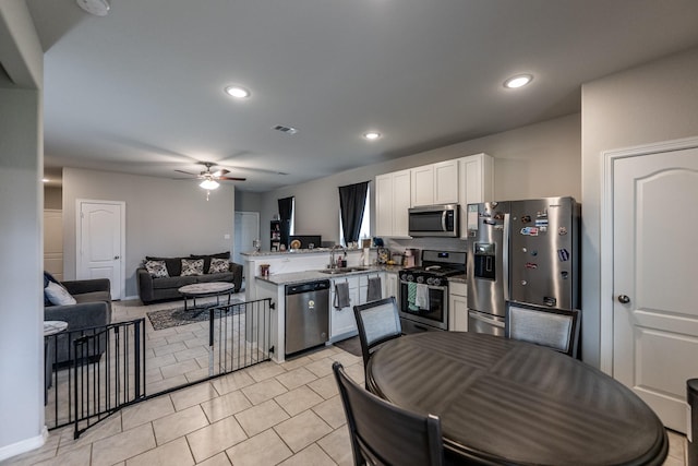25843 Hickory Pecan Trl, Tomball, TX 77375 - kitchen featuring appliances with stainless steel finishes, a sink, ceiling fan, a peninsula, and white cabinets