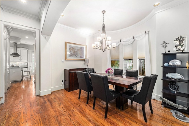 dining area with crown molding, recessed lighting, wood finished floors, a notable chandelier, and baseboards