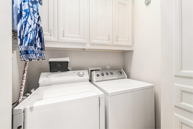 laundry room with independent washer and dryer and cabinet space