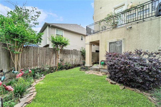 view of yard featuring a balcony and fence