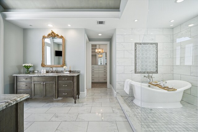 2222 Oxford St, Houston, TX 77008 - bathroom with vanity, a soaking tub, marble finish floor, visible vents, and tile walls