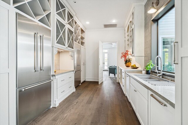 2222 Oxford St, Houston, TX 77008 - kitchen featuring a sink, built in fridge, visible vents, white cabinets, and dark wood-style flooring