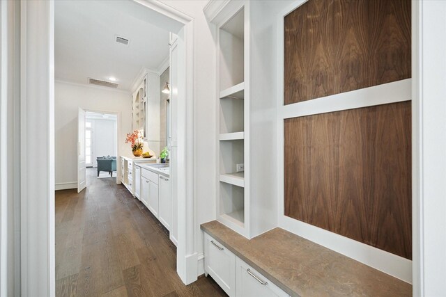 2222 Oxford St, Houston, TX 77008 - interior space featuring built in shelves, visible vents, crown molding, and dark wood finished floors