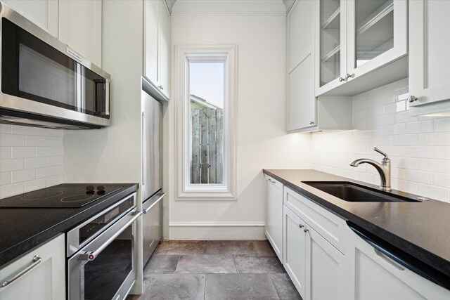 2222 Oxford St, Houston, TX 77008 - kitchen with stainless steel appliances, dark countertops, glass insert cabinets, white cabinetry, and a sink