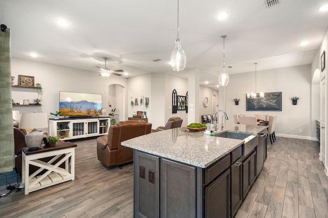 10215 Napier Dr, Rosharon, TX 77583 - kitchen with dishwasher, light wood-style floors, a sink, arched walkways, and recessed lighting
