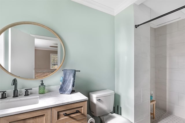 bathroom featuring ornamental molding, a tile shower, toilet, and vanity