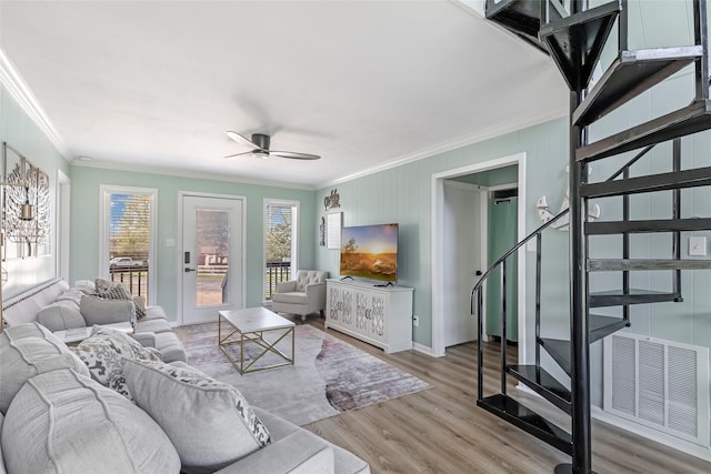 living area featuring visible vents, crown molding, stairs, ceiling fan, and wood finished floors