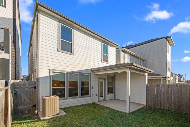 back of house with fence, a patio, a gate, central AC, and a lawn