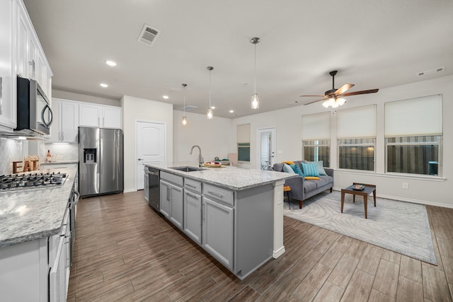 kitchen featuring dark wood-style flooring, a sink, visible vents, a ceiling fan, and appliances with stainless steel finishes