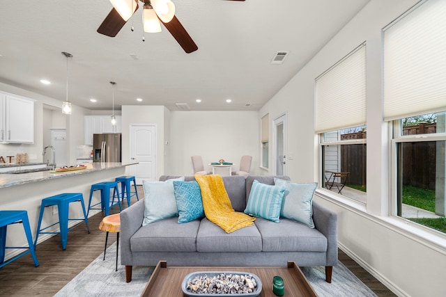 living area featuring wood finished floors, a wealth of natural light, and visible vents