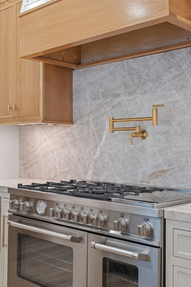 kitchen featuring decorative backsplash, custom exhaust hood, and double oven range