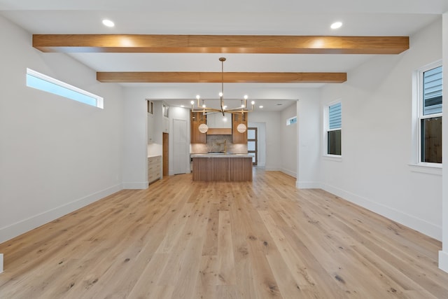 interior space with baseboards, light wood-style floors, beam ceiling, and recessed lighting