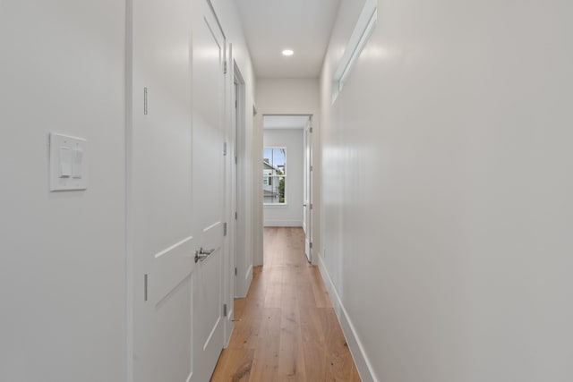 corridor featuring light wood finished floors, baseboards, and recessed lighting