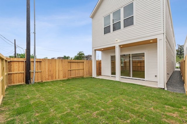 back of property featuring a fenced backyard and a lawn