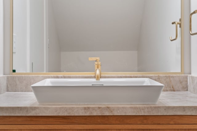 bathroom featuring lofted ceiling and vanity