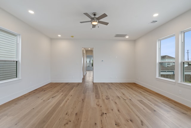 empty room with ceiling fan, baseboards, visible vents, and light wood-type flooring