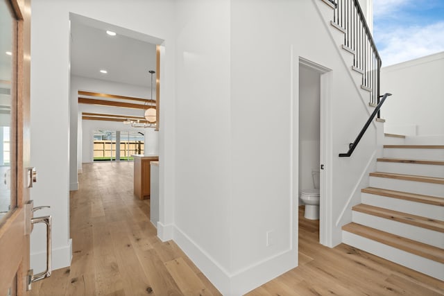 interior space featuring light wood-type flooring, an inviting chandelier, recessed lighting, and stairs