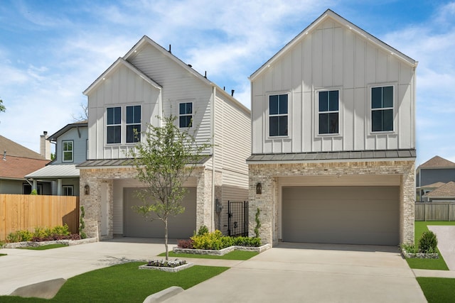 view of front facade featuring board and batten siding, driveway, a standing seam roof, and a garage