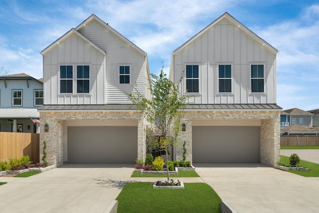 modern farmhouse featuring a standing seam roof, concrete driveway, fence, an attached garage, and board and batten siding