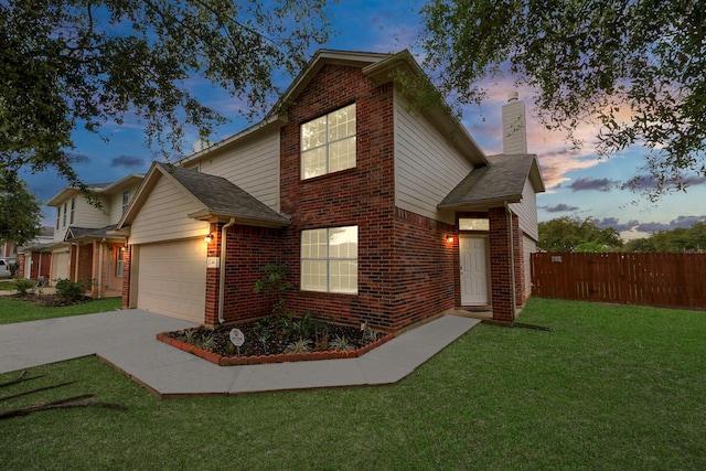 traditional-style home with brick siding, a garage, fence, and a front yard