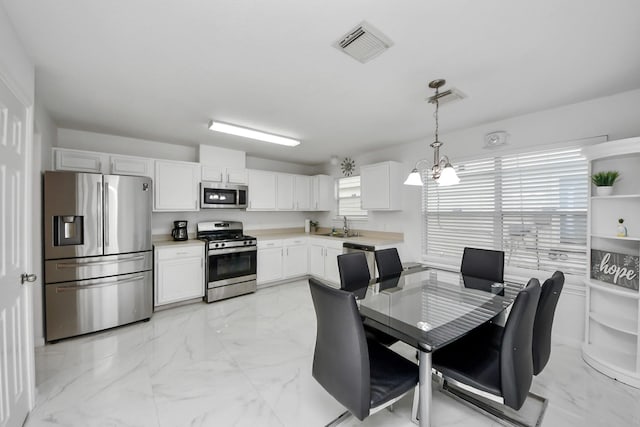 kitchen featuring marble finish floor, a sink, stainless steel appliances, and visible vents