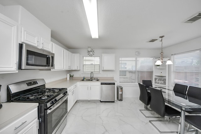 kitchen featuring a sink, visible vents, an inviting chandelier, and appliances with stainless steel finishes