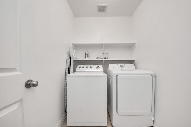 laundry room featuring washer and clothes dryer, visible vents, laundry area, and baseboards