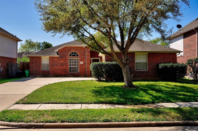 single story home featuring a front yard and brick siding