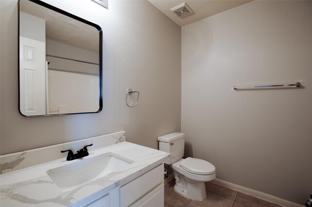 bathroom with visible vents, tile patterned flooring, vanity, baseboards, and toilet