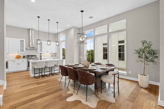 1177 W 19th St, Houston, TX 77008 - dining room featuring a notable chandelier, light wood-type flooring, baseboards, and recessed lighting