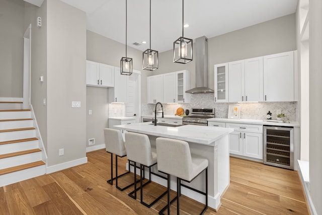 1177 W 19th St, Houston, TX 77008 - kitchen featuring a sink, wall chimney range hood, decorative backsplash, gas stove, and wine cooler