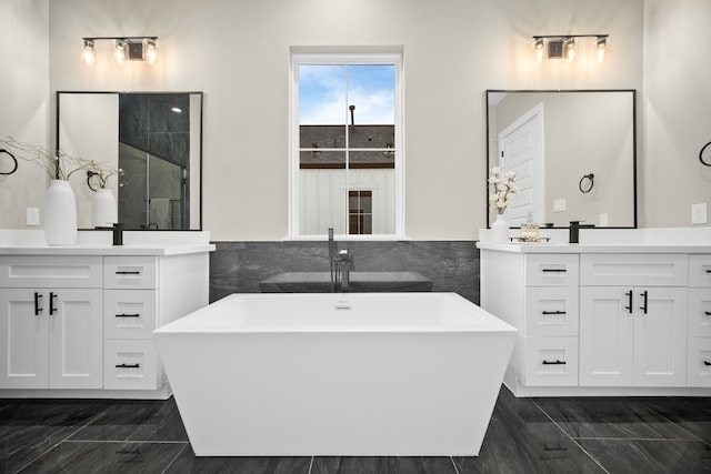 1177 W 19th St, Houston, TX 77008 - bathroom with tile walls, a freestanding tub, two vanities, and a sink