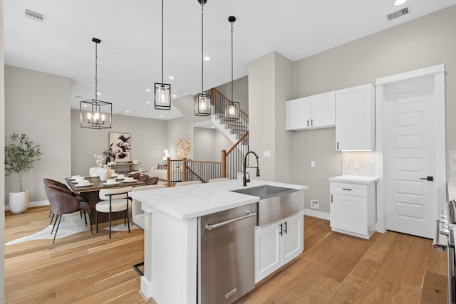 1193 W 19th St, Houston, TX 77008 - kitchen featuring stainless steel dishwasher, a sink, light wood-style flooring, white cabinetry, and recessed lighting