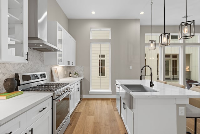 1193 W 19th St, Houston, TX 77008 - kitchen featuring appliances with stainless steel finishes, wall chimney exhaust hood, a sink, light wood finished floors, and decorative backsplash