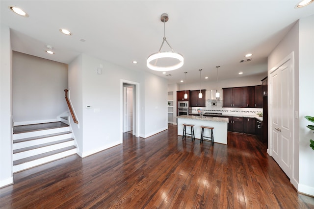 1005 Bingham St Unit 5, Houston, TX 77007 - kitchen with a kitchen island with sink, a kitchen bar, dark wood-type flooring, wall chimney exhaust hood, and dark brown cabinetry